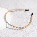 Detail shot of golden headband with colorful crystal beads and pearls on white base - Colorful
