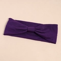 Detailed close-up of dark purple elastic yoga headband with central knot detail and knit texture - Purple