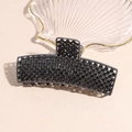 Detail of a large black metal hair claw clip with rhinestones and inner comb teeth - Black Rhinestone
