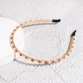 Close-up of thin gold metal headband with sparkling red and white crystal beads - Red