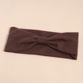Detailed close-up of dark brown ribbed knit elastic headband with a center bow tie knot - Brown
