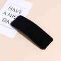 Primer plano de una pinza para el pelo de terciopelo negro sobre un fondo beige suave - Terciopelo Negro Rectangular