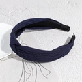 Detail showing deep blue knotted knitted headband with a soft ribbed texture on stone - Navy Blue