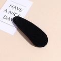 Detalle de una pinza para el pelo negra flocada sobre fondo beige minimalista - Terciopelo Negro Gota