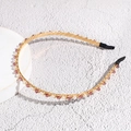 Detail of elegant gold headband with white pearls and purple crystals on white stand - Purple