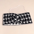Detail van gebreide haarband met pied-de-poule patroon, kruisknoop en elastische band - Zwart