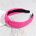Detail of rose pink ribbed fabric headband with stylish knot on a textured background - Rose Red