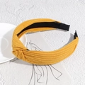 Detail of yellow ribbed knit headband with top knot and non-slip lining on artistic background - Dark Yellow