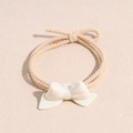 Detailed macro view of a beige elastic hair tie featuring a white resin bow ornament - Bow Off White