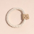 Vue détaillée d'un chouchou spirale blanc avec étiquette en cuir à motif lapin marron - Blanc
