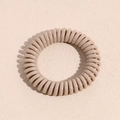 Nahaufnahme eines khakifarbenen Spiral-Haargummis auf beigem Hintergrund mit Schatten - Standardtyp / Koreanisches Rosa