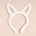 Gros plan du serre-tête oreilles de lapin en peluche blanche sur fond beige - Blanc