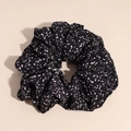 Dettaglio ravvicinato di un elastico per capelli in tessuto nero con pois bianchi - Nero