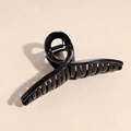Dettaglio di un fermaglio per capelli nero lucido con design a spirale e molla argentata - Croce Nero