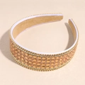 Detalle de diadema de pedrería champán con cadena lateral y forro de terciopelo marrón - Champán
