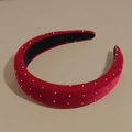 Détail de la texture d'un serre-tête en velours rouge épais avec des strass brillants - Rouge