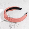 Stylish coral pink knotted headband featuring pleated fabric and wide knit design - Orange Red