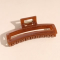 Dettaglio molletta per capelli in acetato ambra con molla dorata e trama traslucida - Quadrato Caffè / Marrone