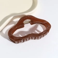 Detail of coffee brown irregular hollow hair claw clip with glossy resin finish - Cloud Shape Brown