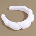 Dettaglio della fascia imbottita bianca in spugna con texture morbida e design a treccia - Bianco