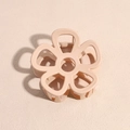 Close-up of a nude pink flower hair claw clip with a glossy finish and metal spring mechanism - Pink