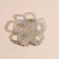 Macro detail of a matte flower hair claw clip with a strong metal spring and resin petals - Translucent Gray