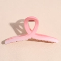 Close-up of pink gradient matte hair claw clip with a minimalist twisted design and jagged teeth - X-Shape Claw