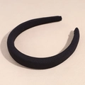 Detail of black wide headband with subtle ribbed fabric texture on a neutral surface - Black