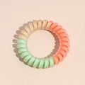Détail d'un élastique spirale mat dégradé en rose pêche, beige et vert menthe clair - Série Vert Clair Orange