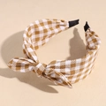 Detail of checkered bow headband showing yellow houndstooth fabric and soft texture - Khaki