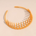 Vue détaillée du serre-tête ondulé orange en plastique avec dents intérieures antidérapantes - Jaune