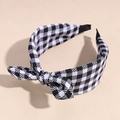 Detail view of a plaid fabric headband with a decorative bow in classic black and white - Black