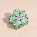 Detailopname van de muntgroene acryl bloem haarklem met zwarte omlijning en roze accent - Groen