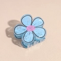 Detailweergave van een blauwe acryl haarklem in bloemvorm op een beige achtergrond - Blauw