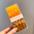 Gros plan d'élastiques en tricot aux tons dégradés chauds dans une boîte transparente - Dégradé Jaune