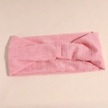 Detailopname van een roze geribbelde yoga hoofdband met een centraal gedraaid knoop - Roze