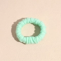 Close-up of mint green elastic hair scrunchie with soft pleated fabric texture - Green