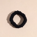 Close-up of black elastic hair tie showing detailed fabric texture and vertical ribs - Black