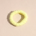 Detailed macro view of a thick pale yellow seamless towel ring hair tie with ribbed texture - Yellow