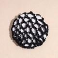 Detail of a black crocheted hair net with rhinestone accents for professional buns - Black