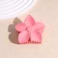 Gros plan d'une pince à cheveux fleur rose mate avec des dents solides sur beige - Rouge Pastèque