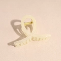 Vista detallada de una pinza para el pelo amarillo pálido con diseño de anillo retorcido - Beige