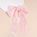Detail einer rosa Perlglanz-Haarklammer mit Organza-Schleifen auf weißem Tablett - Rosa