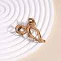 Detail of matte brown butterfly hair claw clip with openwork design on a white plate - Coffee with Bow