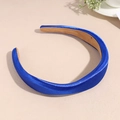 Détail du serre-tête en satin bleu roi avec rembourrage en éponge sur fond de texture beige - Bleu marine