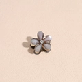 Dettaglio di un mini fermaglio a fiore con petali glitter viola e strass centrale luminoso - grigio scuro