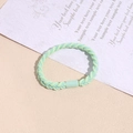 Detail of woven mint green hair tie with braided texture and cylindrical clasp - Fruit Green