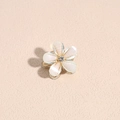 Dettaglio del mini fermaglio per capelli a camelia con petali bianchi e bordo dorato - verde chiaro