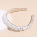 Dettaglio di un cerchietto imbottito largo con perle finte bianche e paillettes argento - Bianco