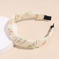 Detailed macro view of floral print headband with cross-wrapped milky white chiffon fabric - Printed Beige